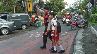 Berikan Rasa Aman, Personil Polsek Gianyar Bantu Anak Sekolah Menyebrang Jalan.
